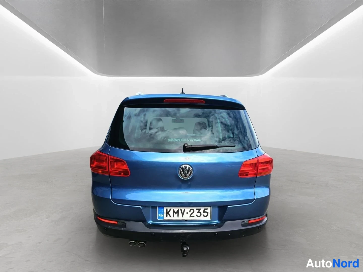 Takaa: Sininen Volkswagen-henkilöauto kuvattuna suoraan takaa; näkyvissä takaluukku, takavalot, VW-merkki, rekisterikilpi, vetoaisa ja kaksi pakoputkea.