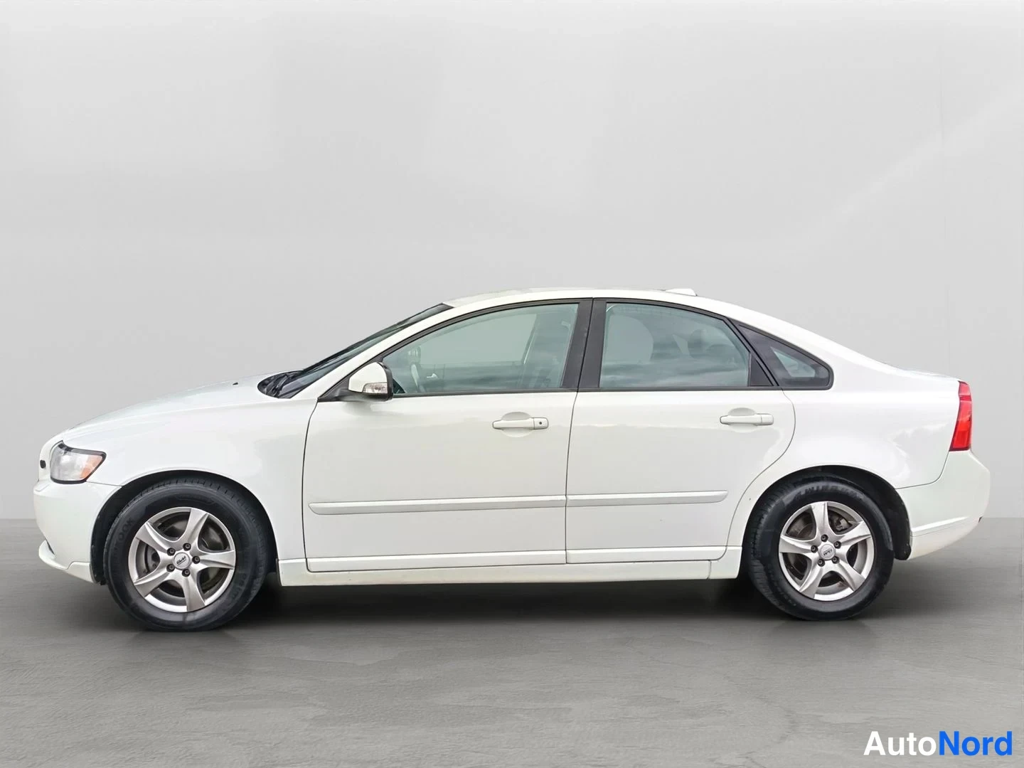 Sivulta: Koko profiilikuvan valkoisesta Volvo S40 -sedanista, jossa on hopeiset kevytmetallivanteet.
