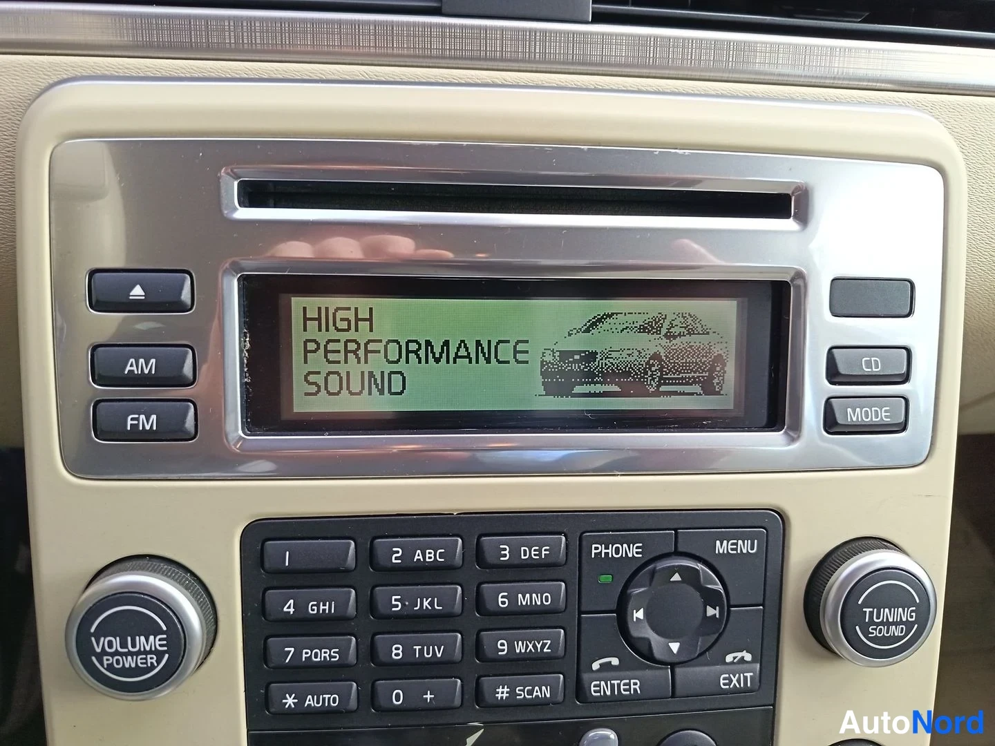 Yksityiskohta: Center console infotainment screen displays the text 'HIGH PERFORMANCE SOUND' alongside a stylized car outline graphic.