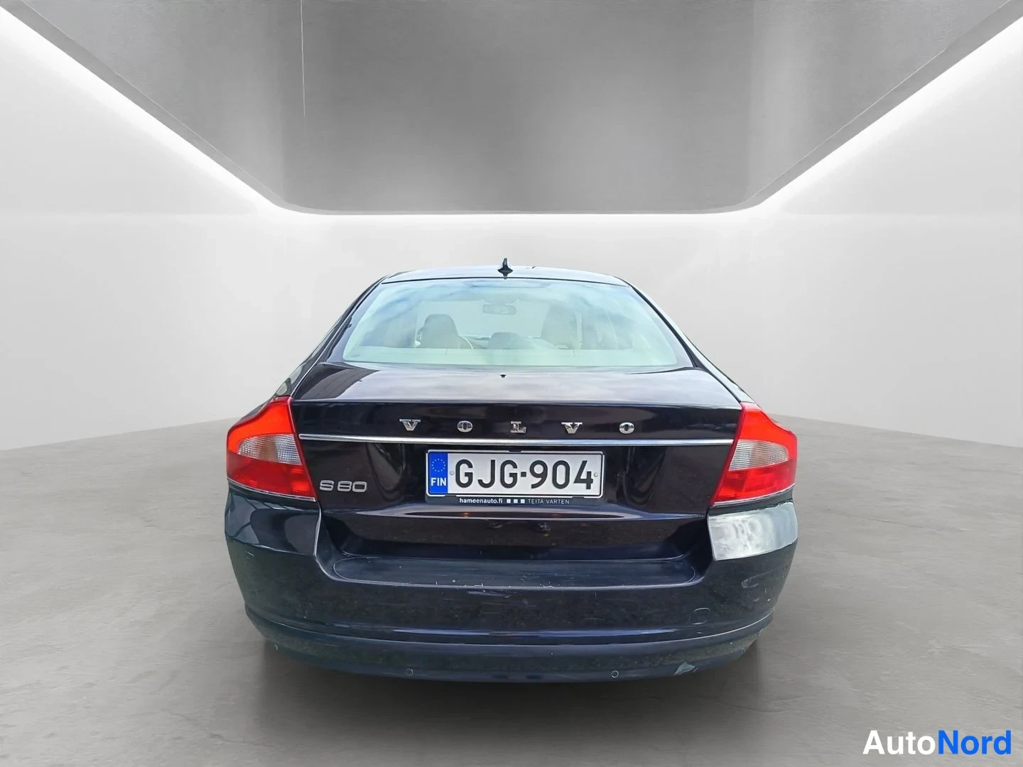 Takaa: Auton takaosa suoraan takaa; musta sedan, VOLVO-kirjaimet, S80-merkintä ja rekisterikilpi.