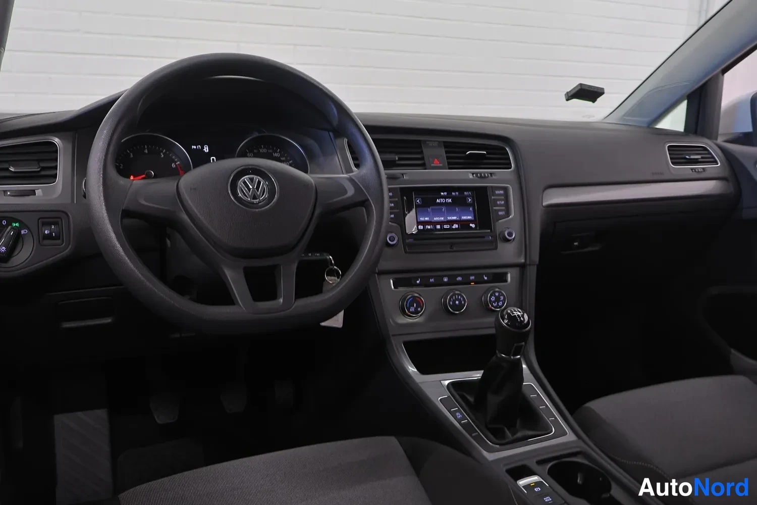 Ohjaamo: Sisäkuva, jossa on koko ohjaamo: ohjauspyörä Volkswagen-logolla, mittaristo, kosketusnäytön radio, kolme kiertoventtiiliä ilmastointia varten, manuaalivaihteist