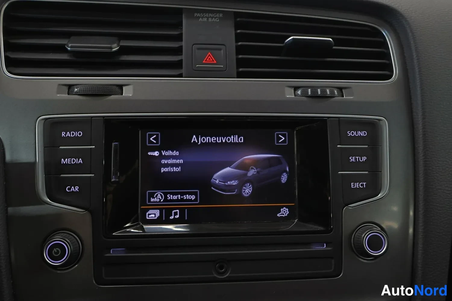 Ohjaamo: In-car assistance menu on the infotainment screen displays a graphic of the vehicle and text about changing the key battery, along with a Start-stop status indi