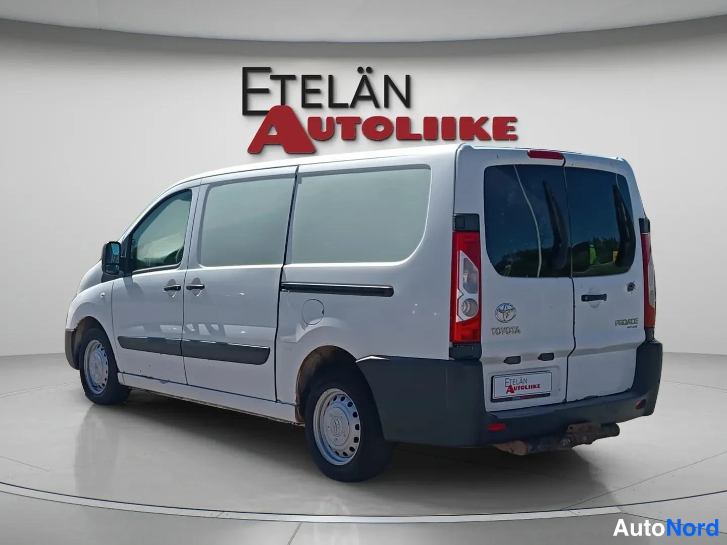 Takaviisto: Valkoinen Toyota Proace -pakettiauto kuvattuna takaa ja vasemmalta sivulta; takaovessa Toyotan ja Proacen merkit.