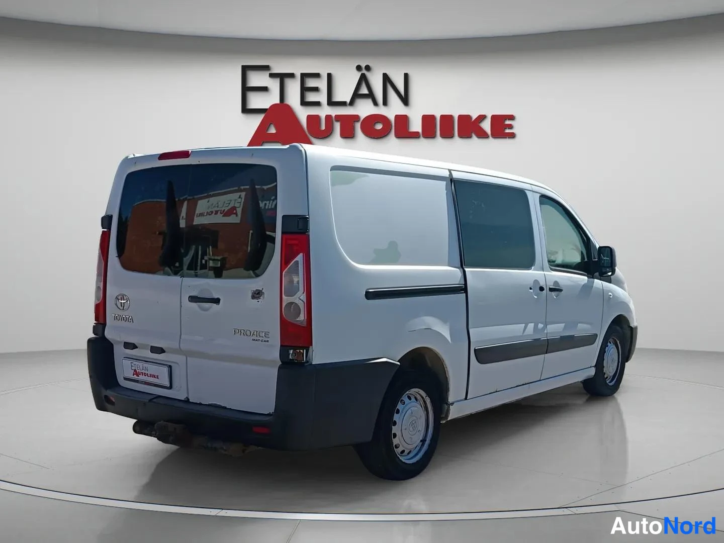 Takaviisto: Valkoinen Toyota Proace -pakettiauto kuvattuna takaa ja oikealta sivulta; takaovessa Toyota- ja Proace-merkit.