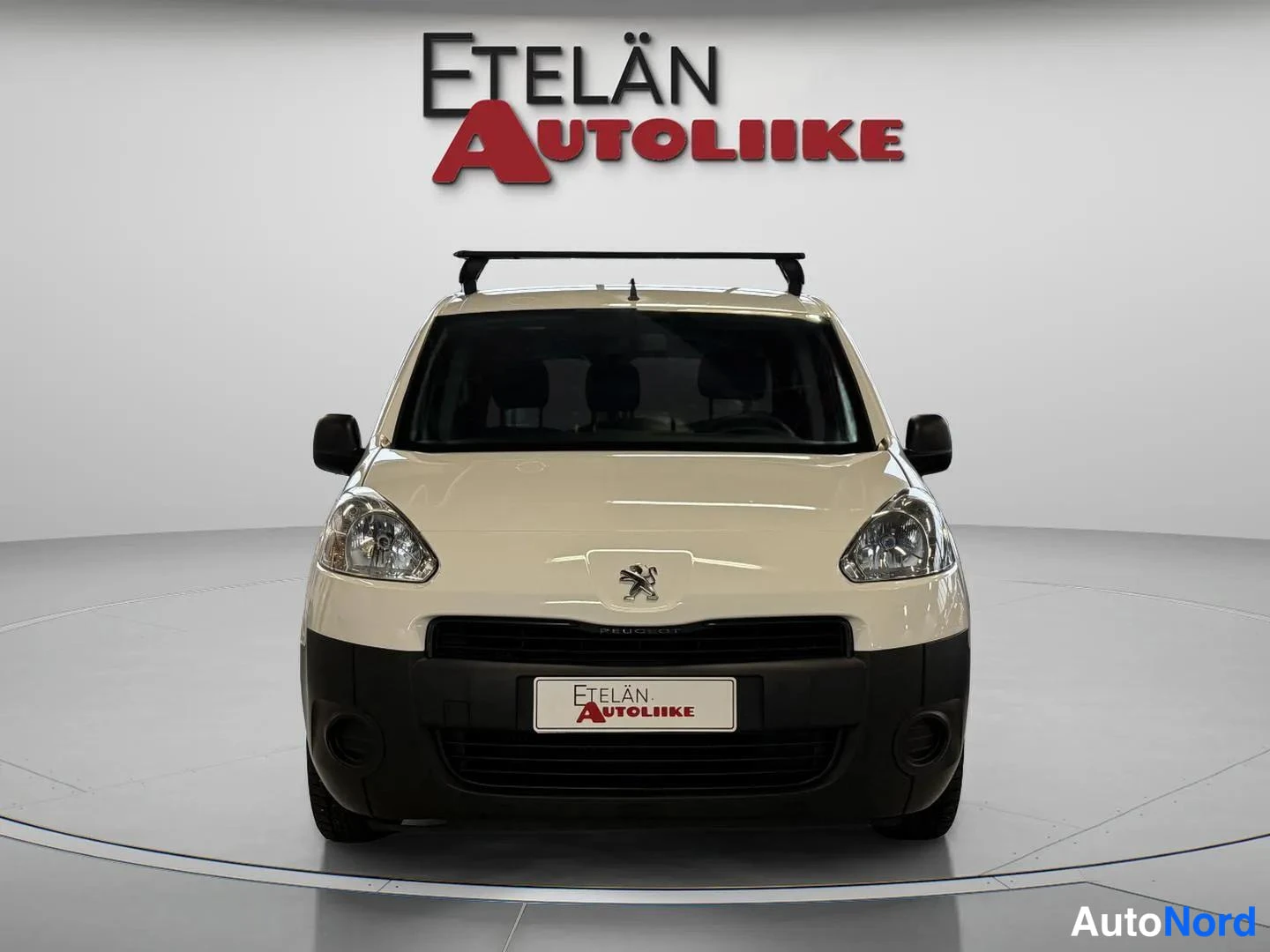 Edestä: Valkoinen Peugeot Partner suoraan edestä päin kuvattuna; kattoteline katolla.