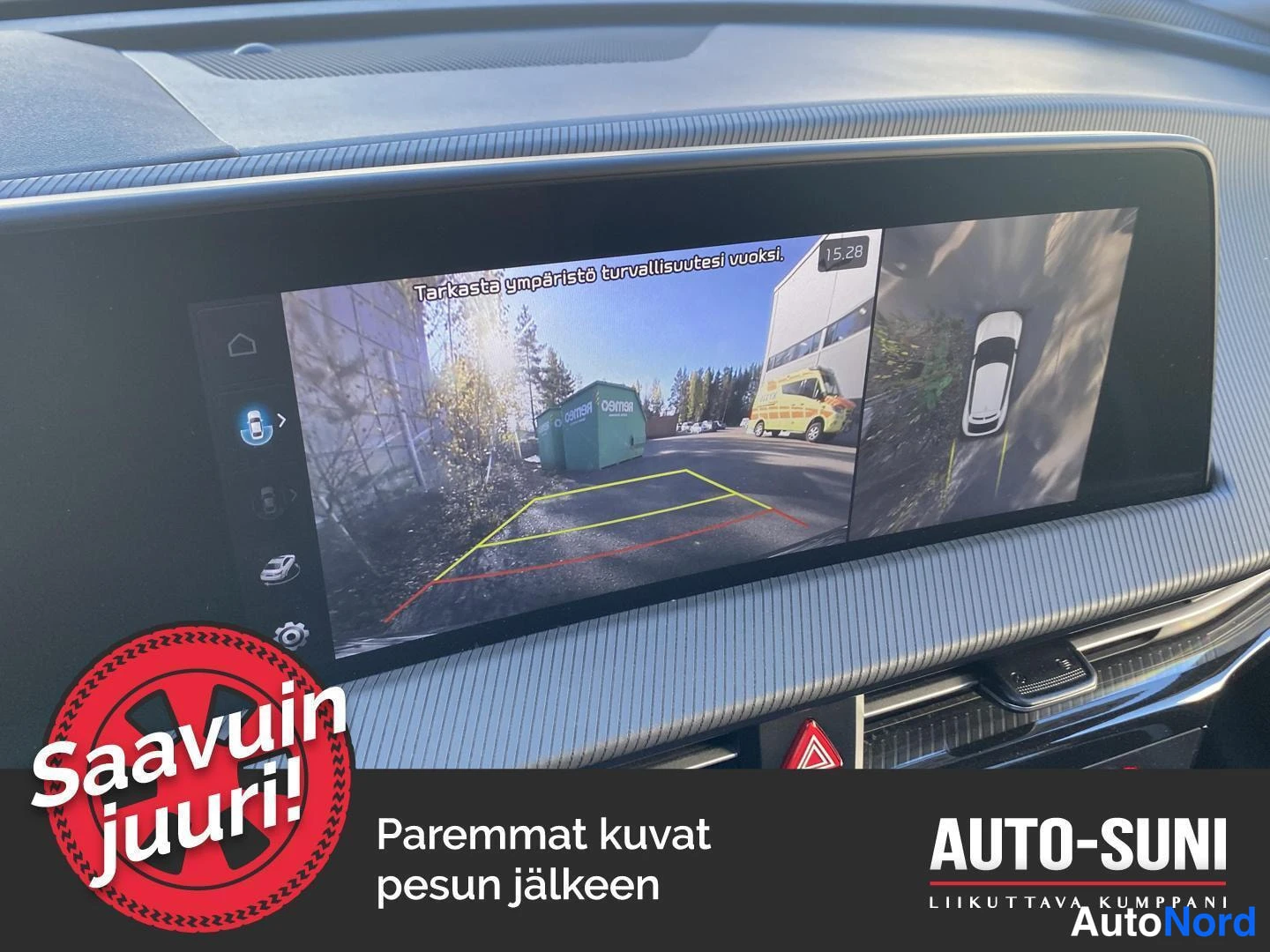 Muu: Kojelaudan infotainment-näyttö näyttää ympäristökameran 360°-näkymän: takakameran kuva parkkiointilinjoineen ja ajoneuvon ylhäältä kuvattu malli.