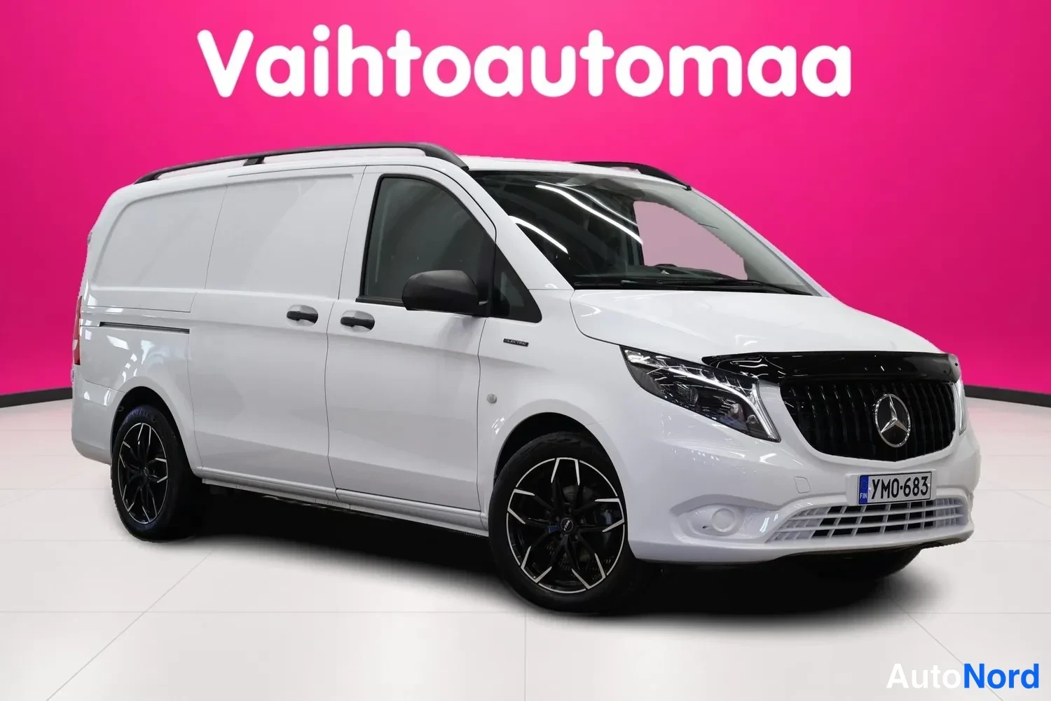 Etuviisto, nokka oikealle: Valkoinen pakettiauto kuvattu kolmannesta etunurkasta, oikea kylki ja etupää näkyvissä, rekisteritunnus.