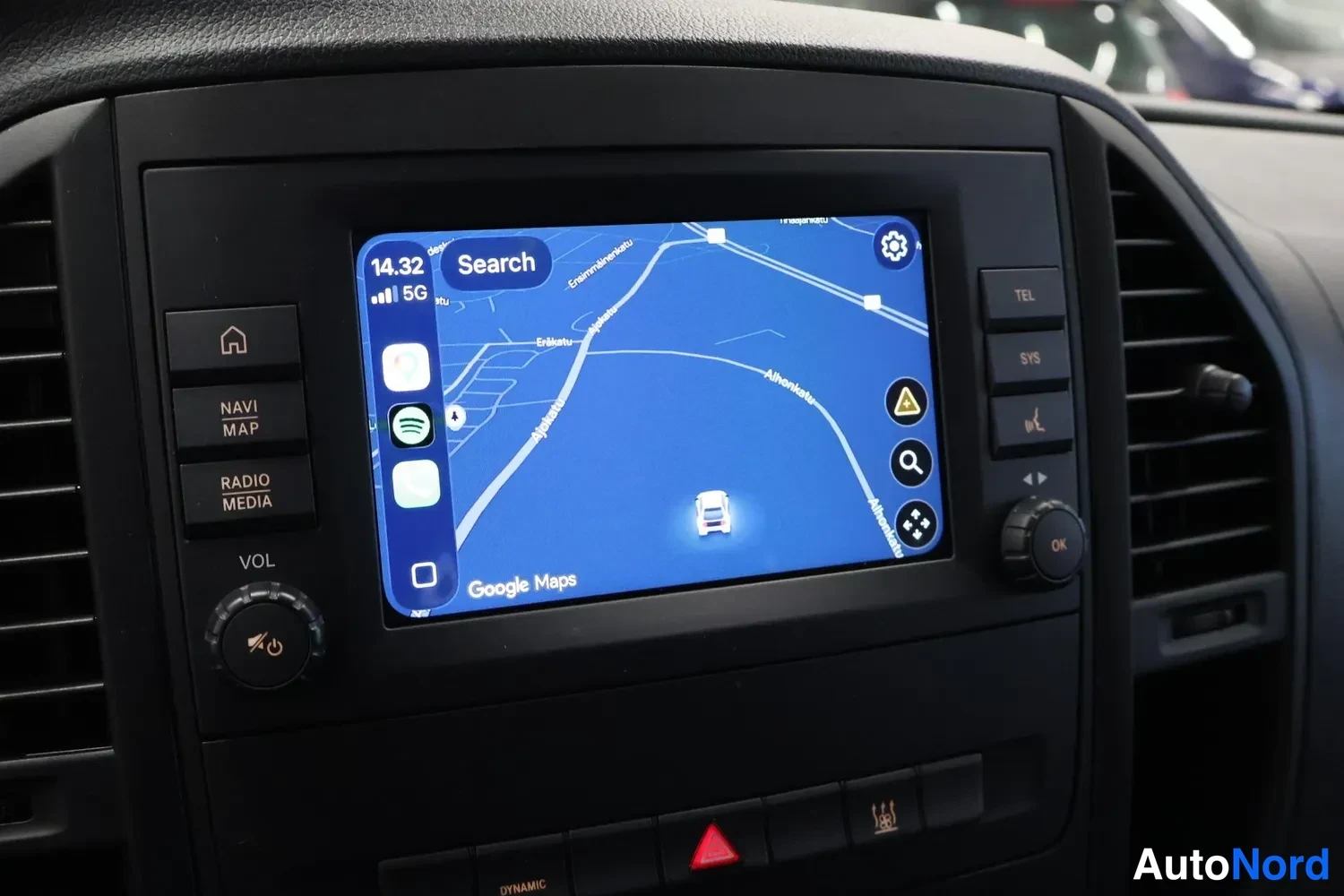 Sivulta: Kojeiston keskiosan näyttö, jossa Google Maps karttanäkymä ja äänipainikkeet NAVI, RADIO/MEDIA ja TEL.