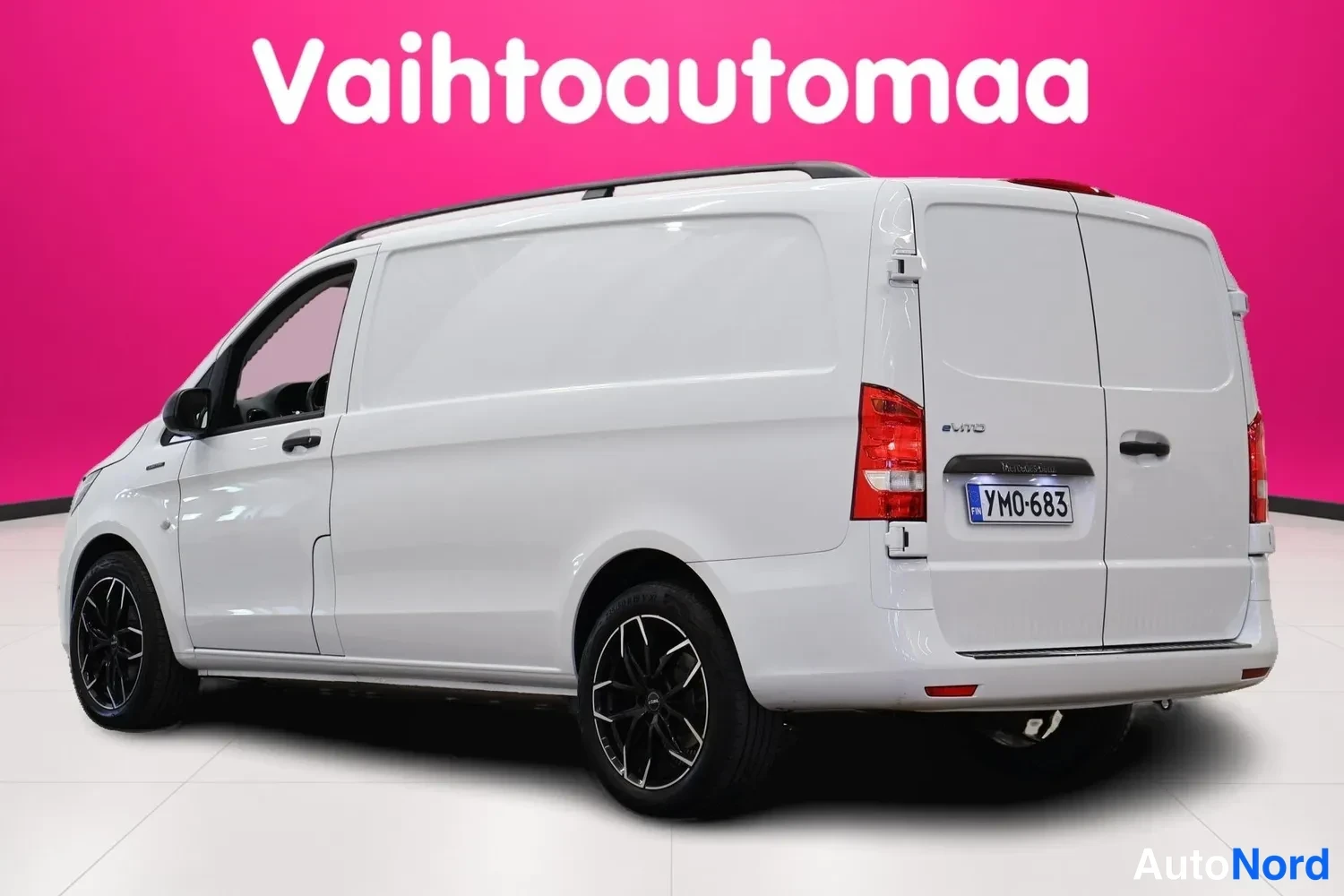 Takaviisto: Valkoisen pakettiauton takaosa ja vasen sivu kolmasosakulmasta; rekisterikilpi YM0-683, punaiset takavalot ja kattokiskot.