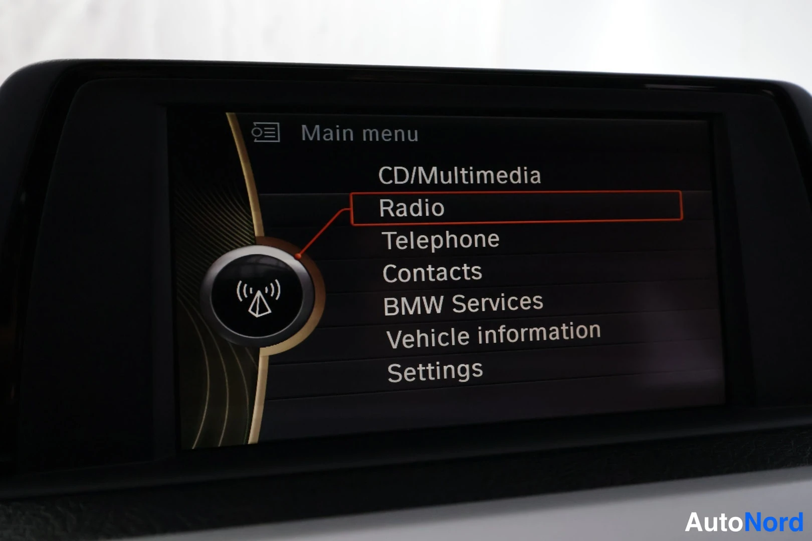 Muu: Infotainment-näytön päävalikko (Main menu): CD/Multimedia, Radio (oranssilla kehyksellä korostettuna), Telephone, Contacts, BMW Services, Vehicle information ja