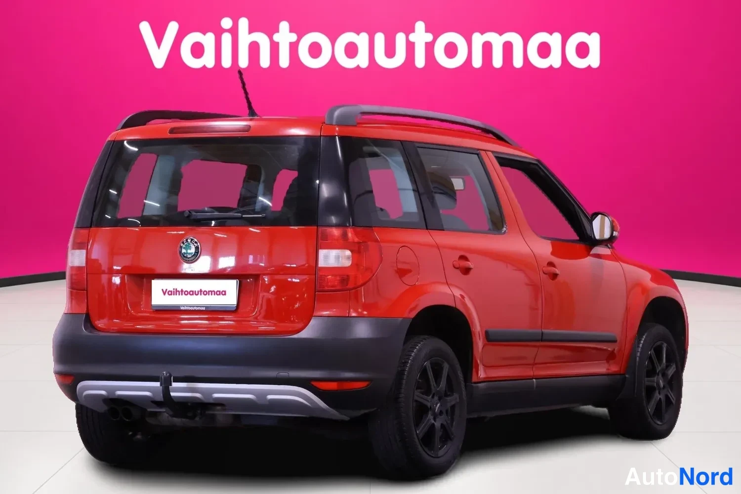 Takaviisto: Punainen Skoda Yeti takakulmakuvassa, takaosa ja kylki näkyvissä; kattokaiteet, vetokoukku ja mustat vanteet.