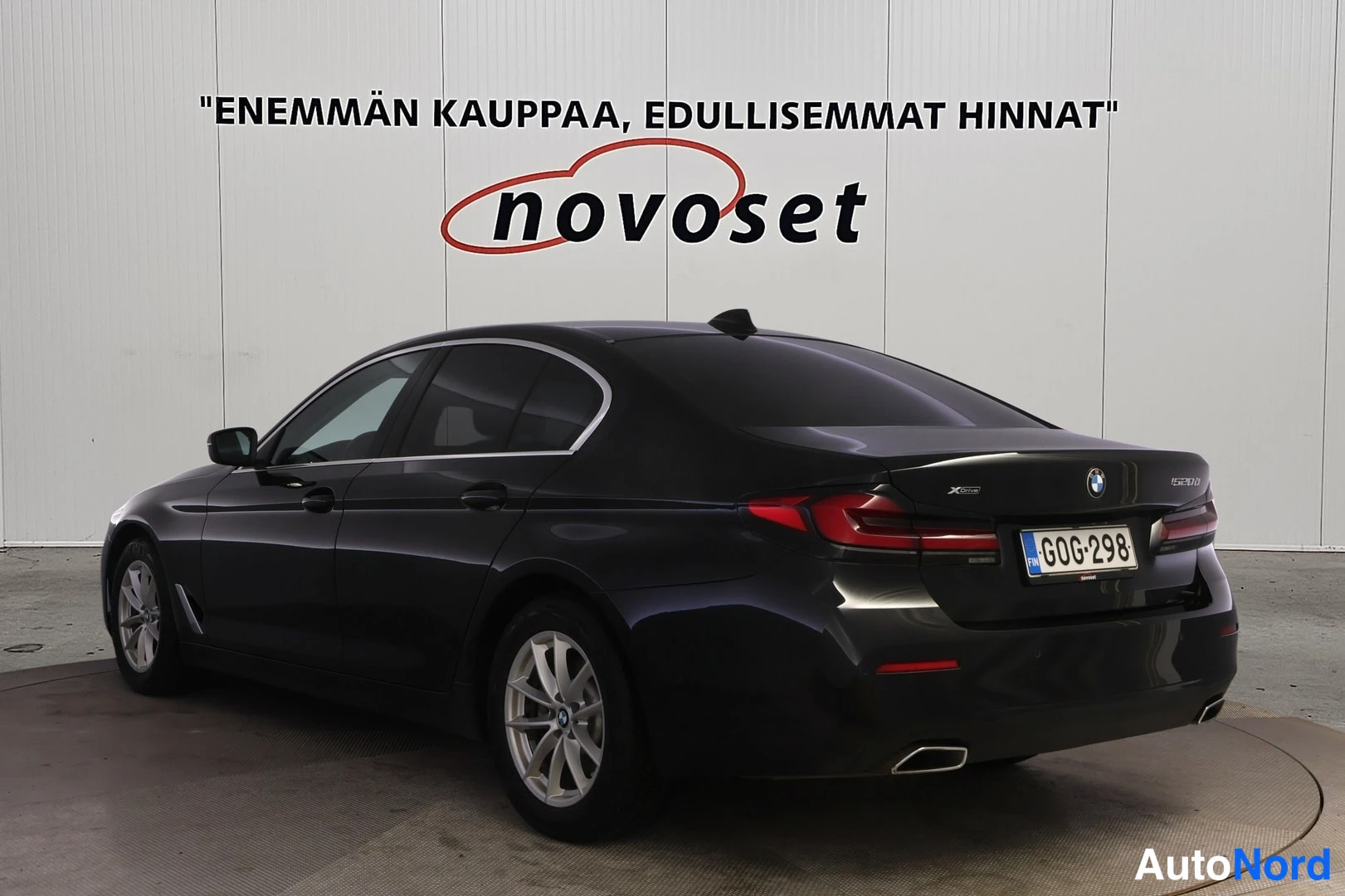 Takaviisto: Mustan BMW-sedanin takaviistonäkymä, perä oikealla; takavalot, takakontti ja vasen kylki näkyvät, rekisterikilpi.
