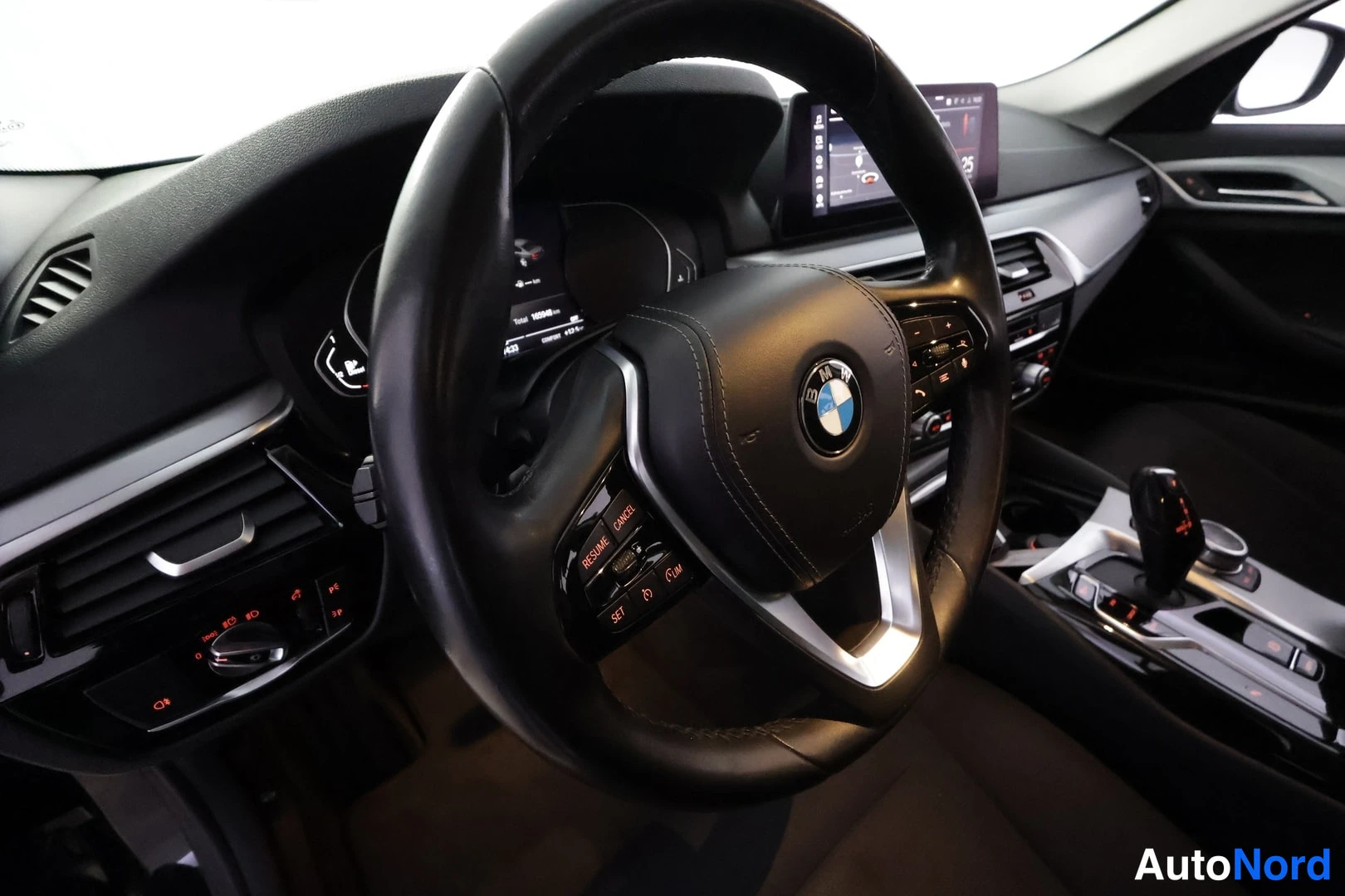 Muu: Ohjaamon yleiskuva: BMW-merkkinen ohjauspyörä, kojelautanäytöt, keskikäyttöpaneeli ja automaattivaihteen valitsin.