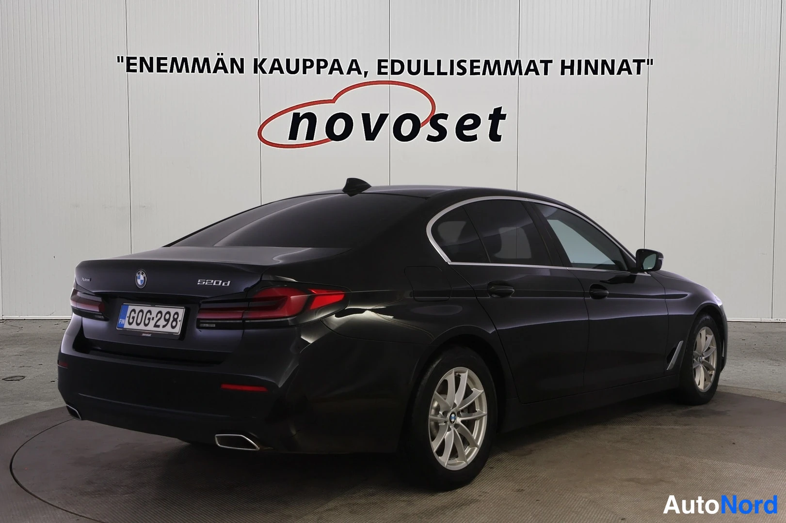 Takaviisto: Mustan BMW-sedanin takaviistonäkymä, perä vasemmalla; takavalot, 520d-merkintä ja oikea kylki näkyvät, rekisterikilpi.