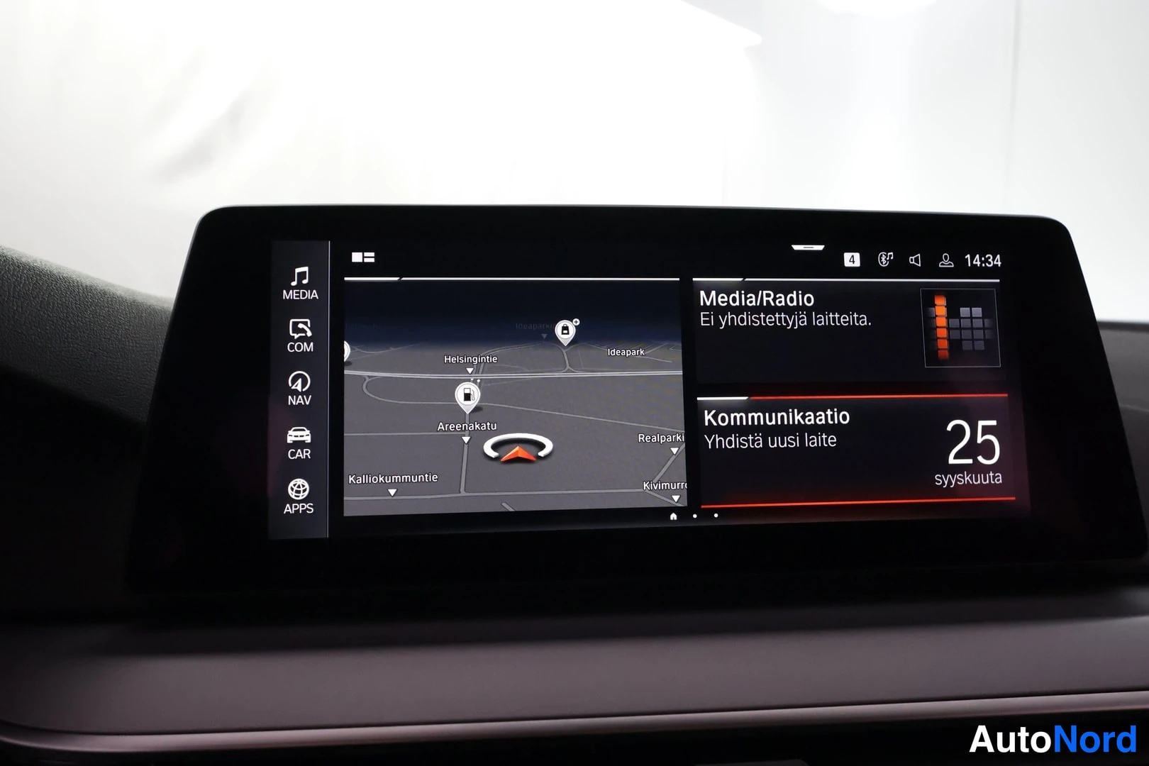 Yksityiskohta: Ajonäytön infotainment-näyttö, jolla näkyy navigointikartta ja Media/Radio- sekä Kommunikatio-valikot.