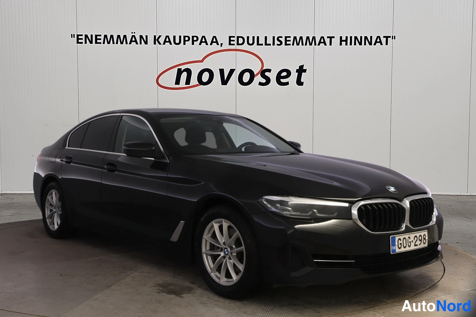 Etuviisto, nokka oikealle: Mustan sedanin etukulmakuva keula oikealla: etusäleikkö, ajovalot, konepelti ja kylki näkyvissä, rekisterikilpi.