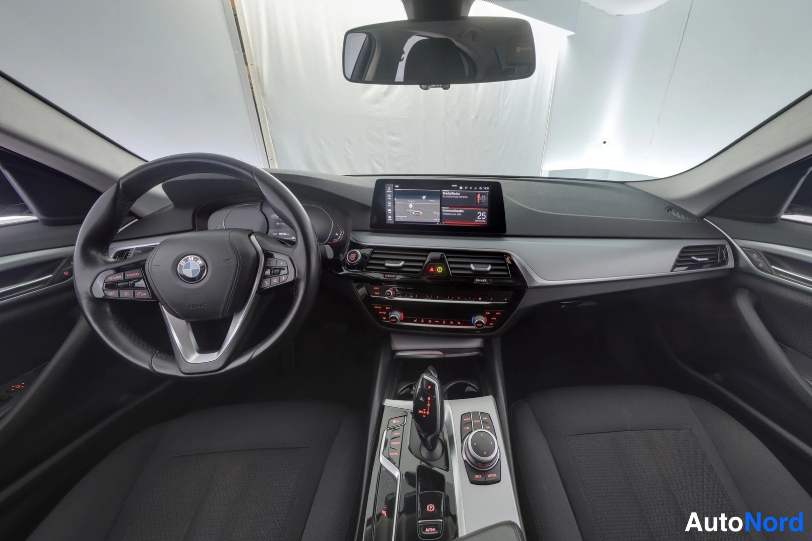 Muu: Sedanin ohjaamo ylhäältäpäin: BMW-ohjauspyörä, mittaristo, keskusnäytöllä toimiva infotainment ja keskikonsolin vaihteenvalitsin sekä iDrive-ohjain.