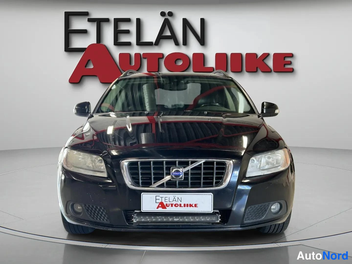 Edestä: Mustan auton suora edustakuva: etusäleikkö Volvo-merkillä, sumuvalot ja LED-valopalkki etupuskurissa, taustalla Etelän Autoliike -kyltti.