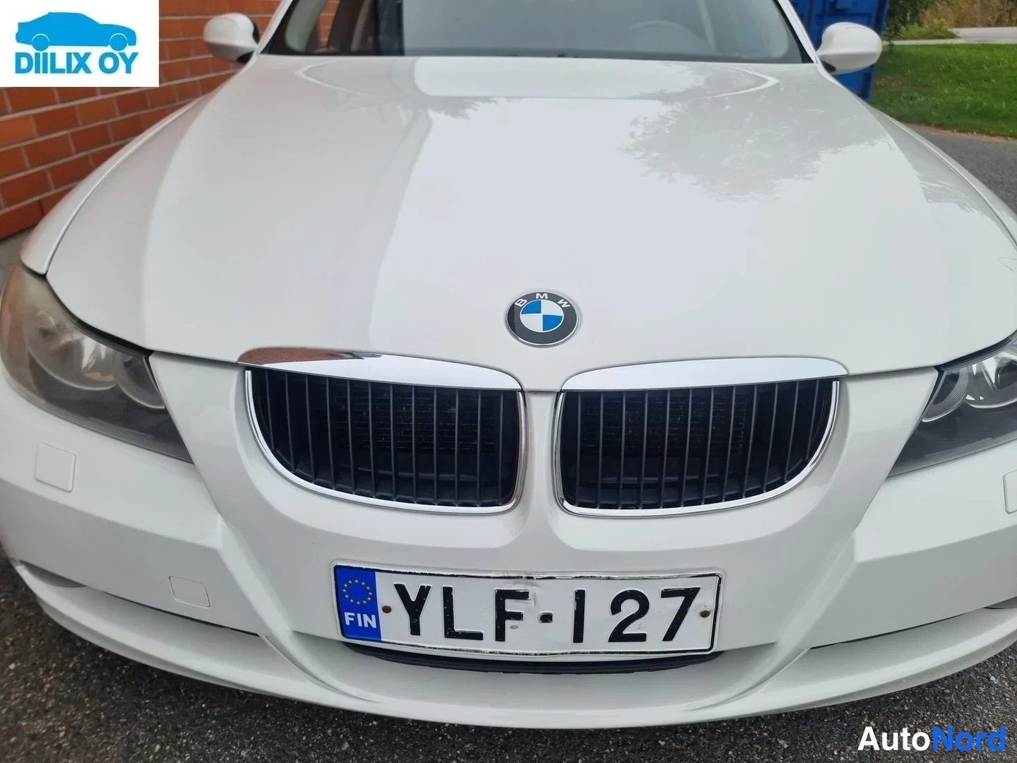 Edestä: Valkoiset BMW:n etupää: etusäleikkö, BMW-emblem ja rekisterikilpi.