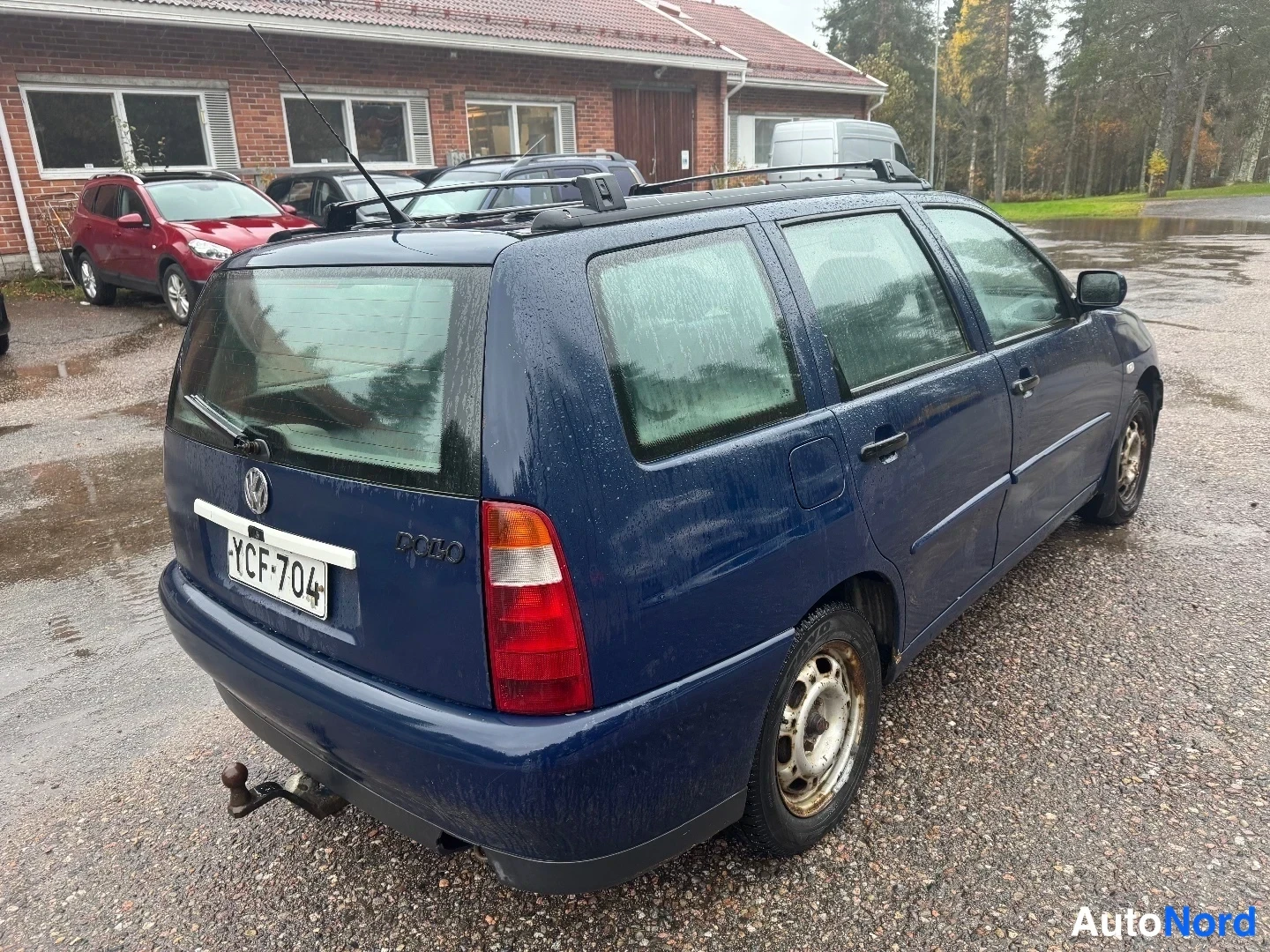 Takaviisto: Sinisen farmarinautowan takanurkkakuva, rekisterikilpi, kattoteline ja rekivetoinen kytkin näkyvissä.