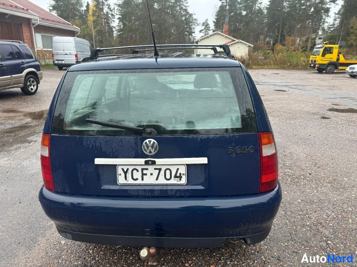 Takaa: Sininen Volkswagen Polo Variant takaa nähtynä, VOLKSWAGEN-merkki, POLO-tunnus, rekisterikilpi ja katetowkupu.