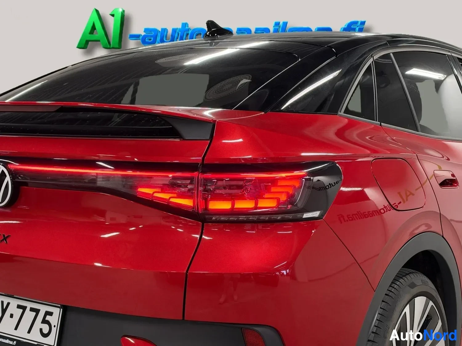 Takaviisto: Punaisen Volkswagenin takaosa ja takavalo lähikuvassa.