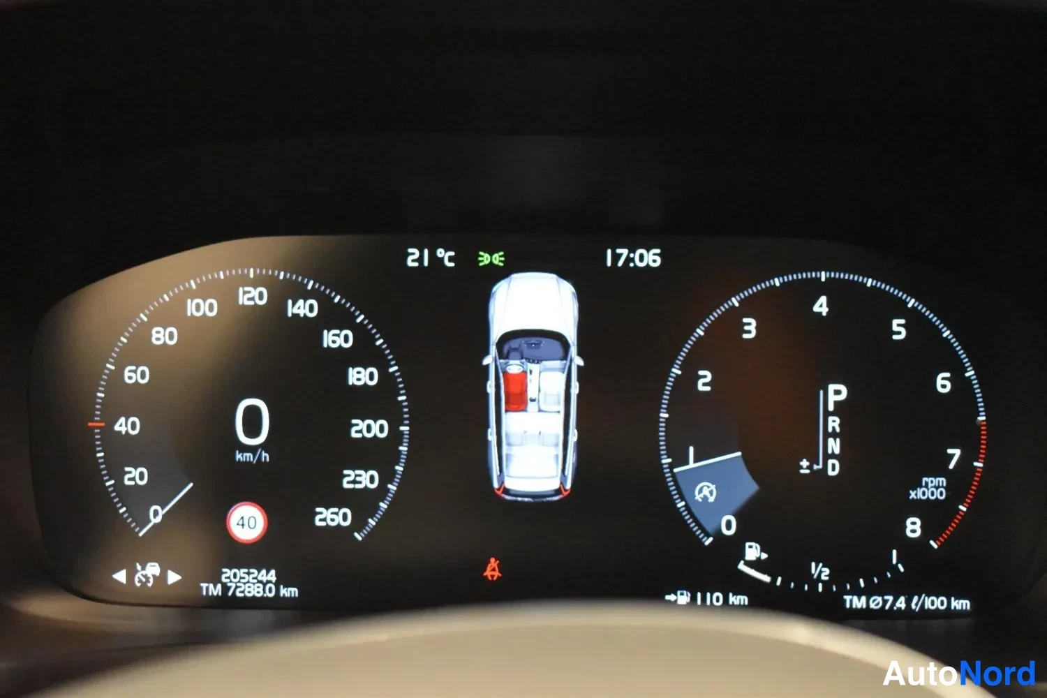Yksityiskohta: Digitaalinen mittaristö: nopeusmittari 0 km/h, kierroslukumittari, P-vaihde, kokonaislukema 205244 km ja Tripmeter 7288.0 km, ulkolämpötila 21 °C, kello 17:06.