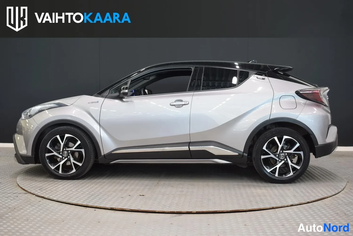 Etuviisto, nokka vasemmalle: Hopeanharmaa Toyota C-HR kyljestä vasemmalta, kattokaari ja musta katto näkyvät.