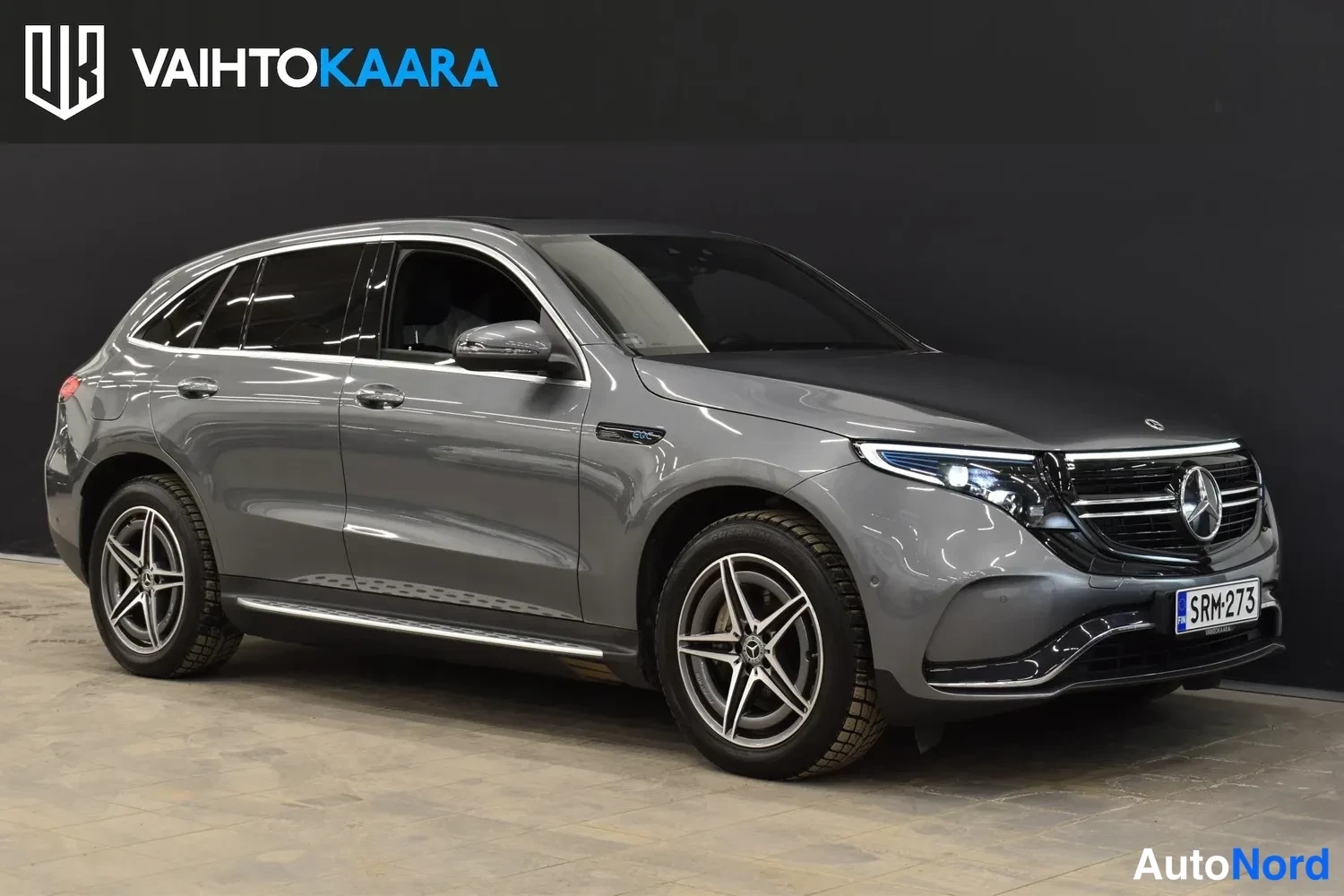 Etuviisto, nokka oikealle: Harmaa Mercedes-Benz EQC etuviistossa, etupanssarissa rekisterikilpi.