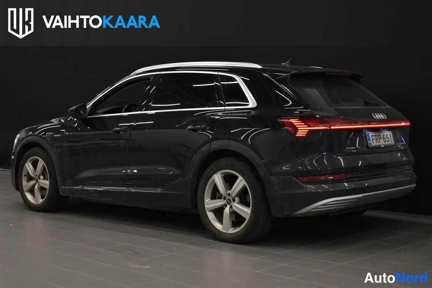 Takaviisto: Audi e-tron takakulmasta oikealta; keskellä jatkuvat takavalot, rekisterikilpi.