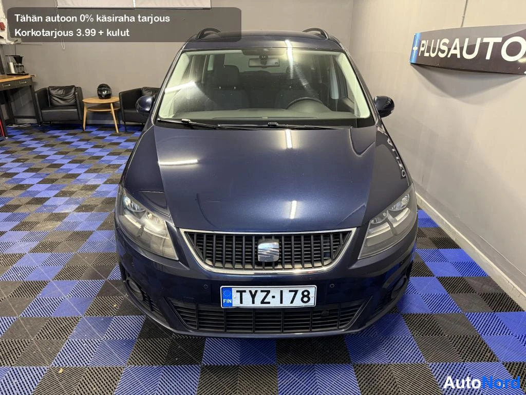 Edestä: Tummansinisen Seat Alhambran suora etukuva sisätiloissa, rekisteritunnus.