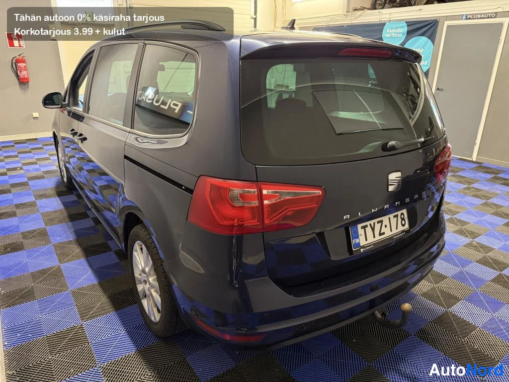 Takaviisto: Takaviistokuva Seat Alhambrasta toiselta sivulta: takavalot, SEAT-merkki, ALHAMBRA-teksti, rekisterikilpi, kattokaiteet ja vetokoukun pallo näkyvät. Korin väri