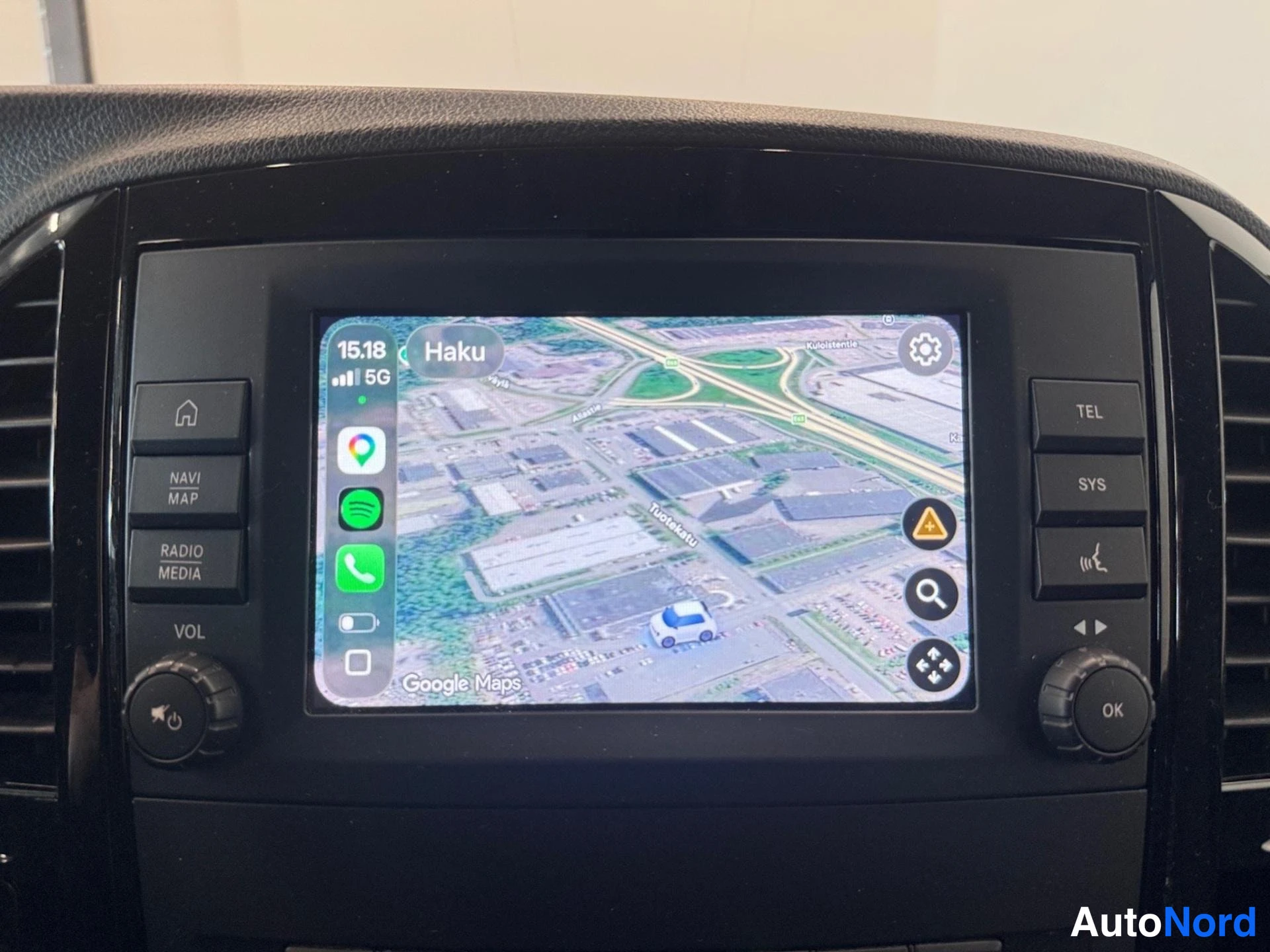 Yksityiskohta: Kojeiston infotainment-näyttö Apple CarPlay -käyttöliittymällä, Google Maps -karttanäkymä ruudussa; sivuilla NAVI MAP-, RADIO MEDIA-, TEL- ja SYS-painikkeet.