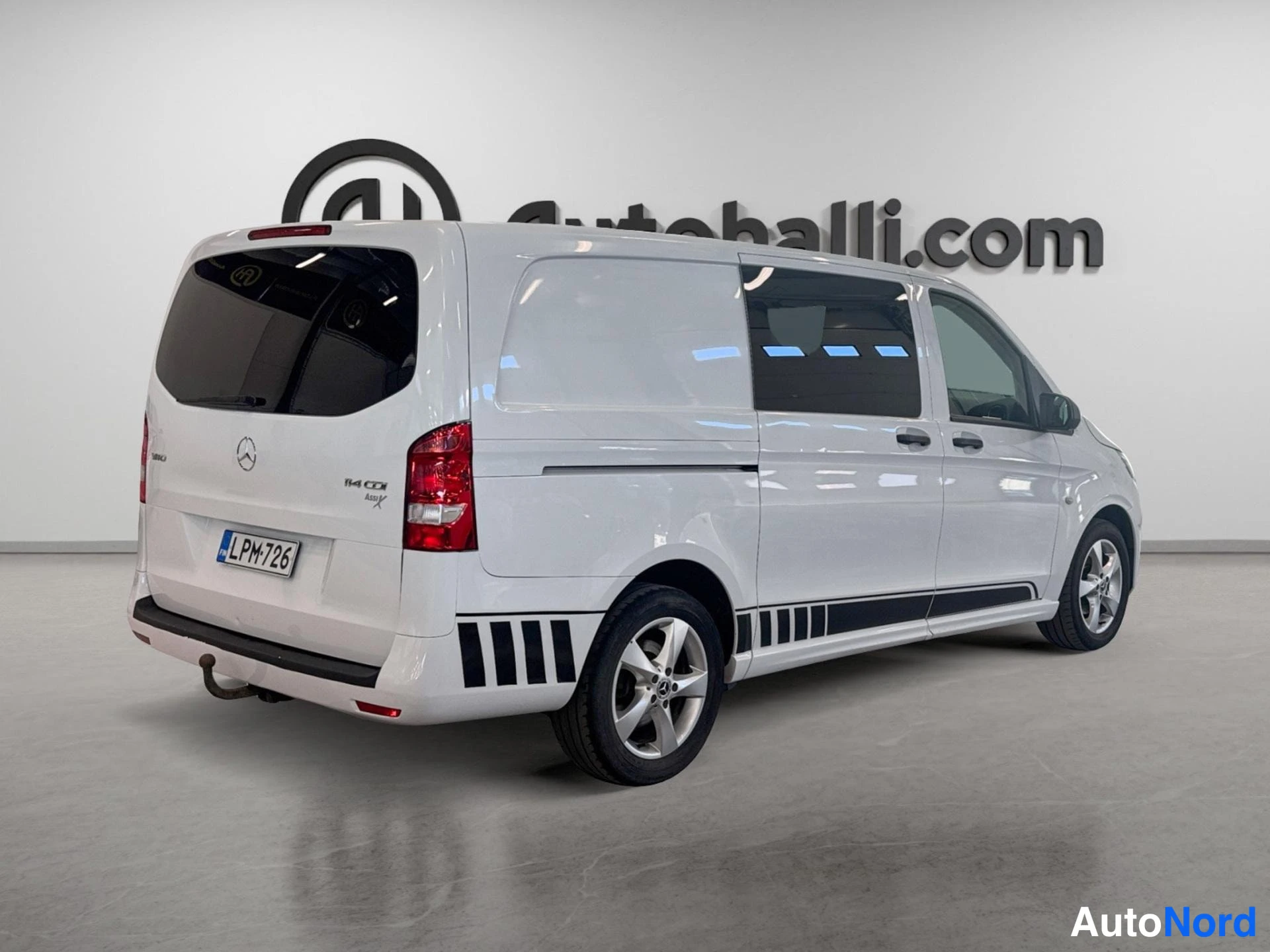 Takaviisto: Valkoinen pakettiauto (Mercedes-Benz Vito) kuvattu takaa sivusuunnasta; takavalo, peräluukku ja rekisterikilpi näkyvät.