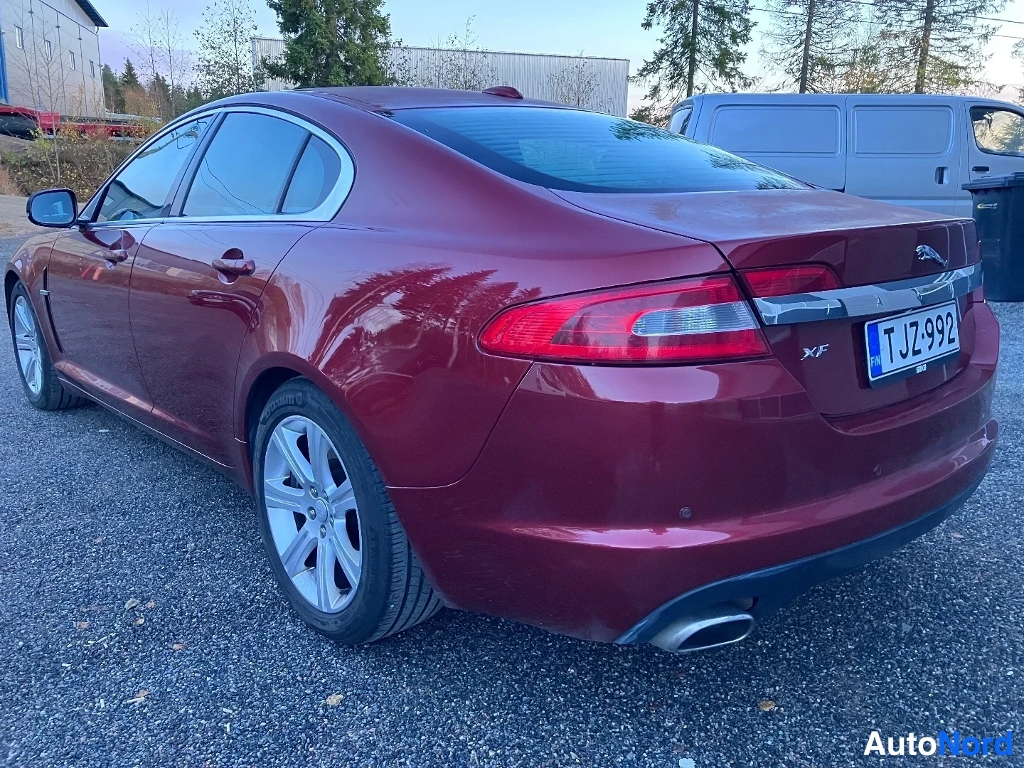 Takaviisto: Punainen Jaguar XF takatilan ja vasemman sivun kuvassa