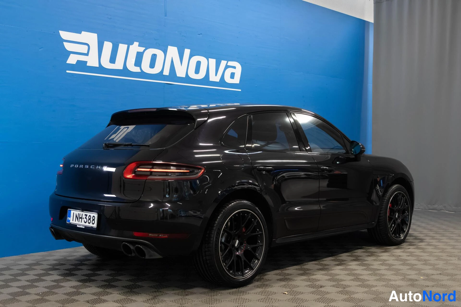 Takaviisto: Mustan Porsche Macan -maasturin takakulmanäyttö vasemmalta, PORSCHE-teksti takaluukussa, rekisteritunnus ja neljä pakoputkea.
