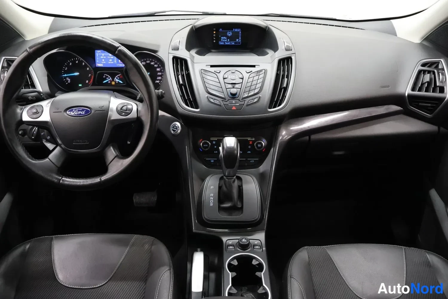 Muu: Etupenkkien takaa kuvattu ohjaamo: Ford-ohjauspyörä, kojelauta, keskinäytönradio ja automaattivaihteen valitsin.