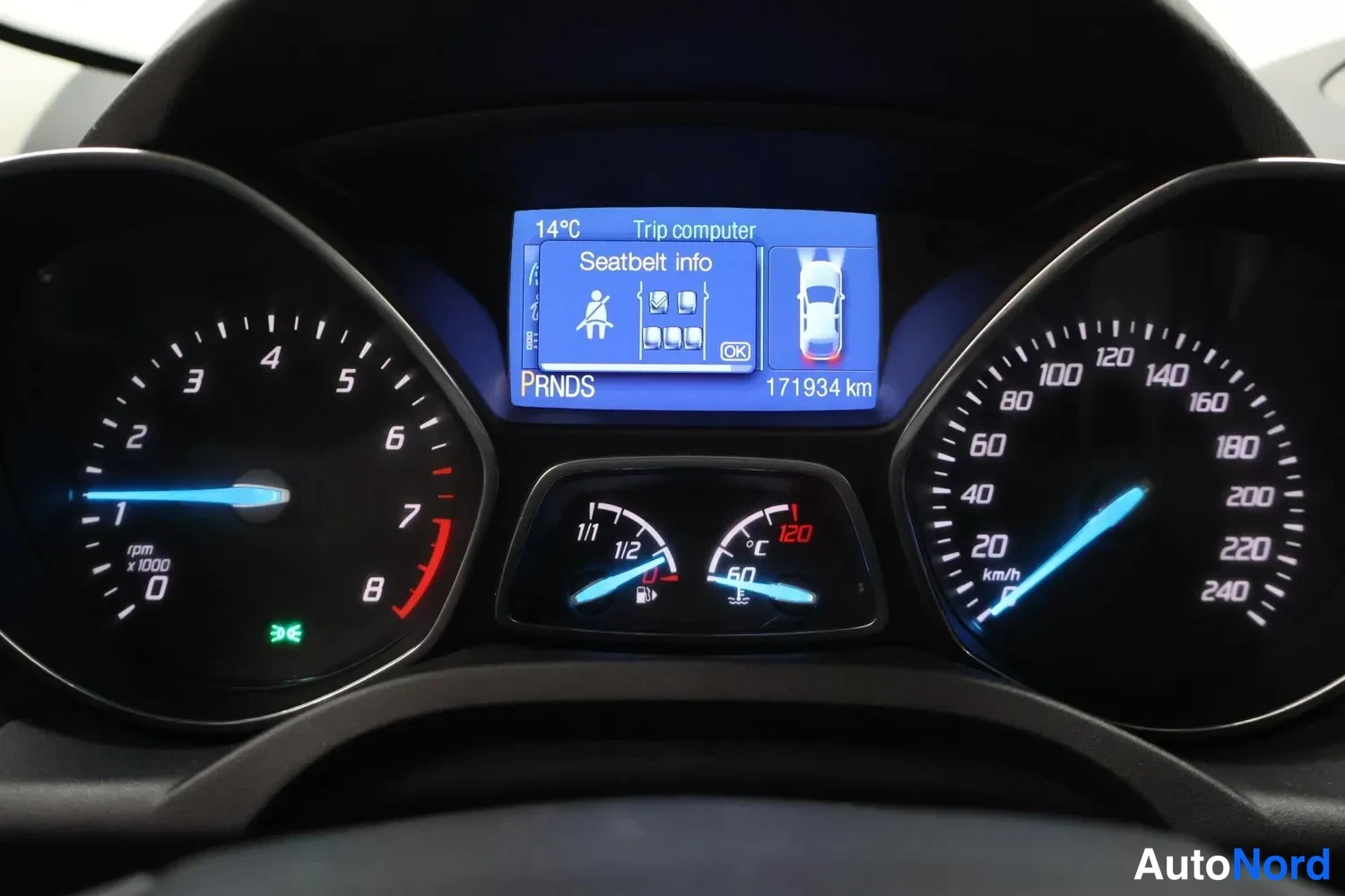 Yksityiskohta: Mittaristo, jossa analogiset kierroslukemittari (0–8 x1000) ja nopeusmittari (0–240 km/h). Keskellä näyttö, jossa teksti 'Trip computer', 'Seatbelt info', 'PRND