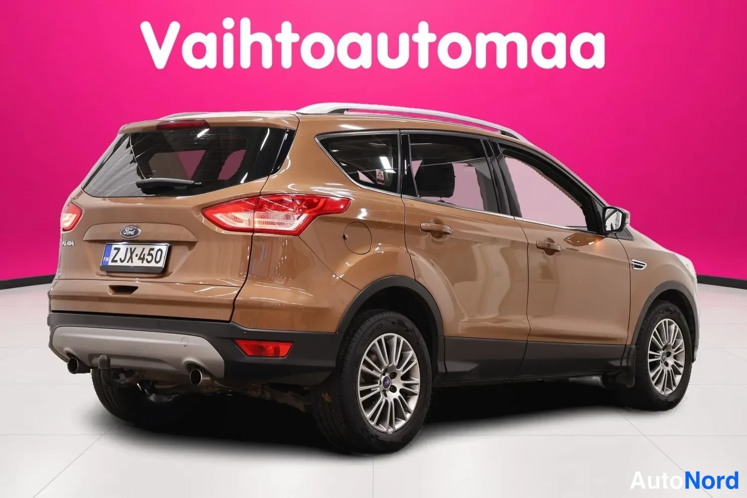 Takaviisto: Ford Kuga takaviistosta kuvattuna, ruskea koriväri, rekisteritunnus, hopeiset vanteet ja kattokaiteet.