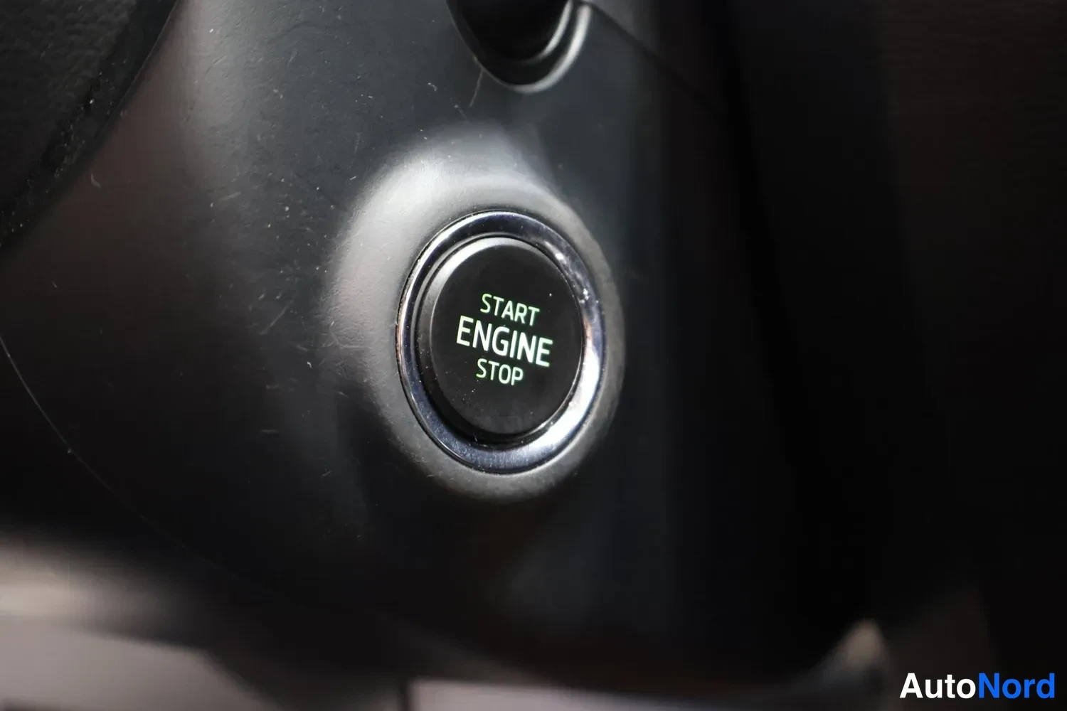 Yksityiskohta: START ENGINE STOP -käynnistysnappi, tekstillä START ENGINE STOP ja keramiikkapinnoitteella