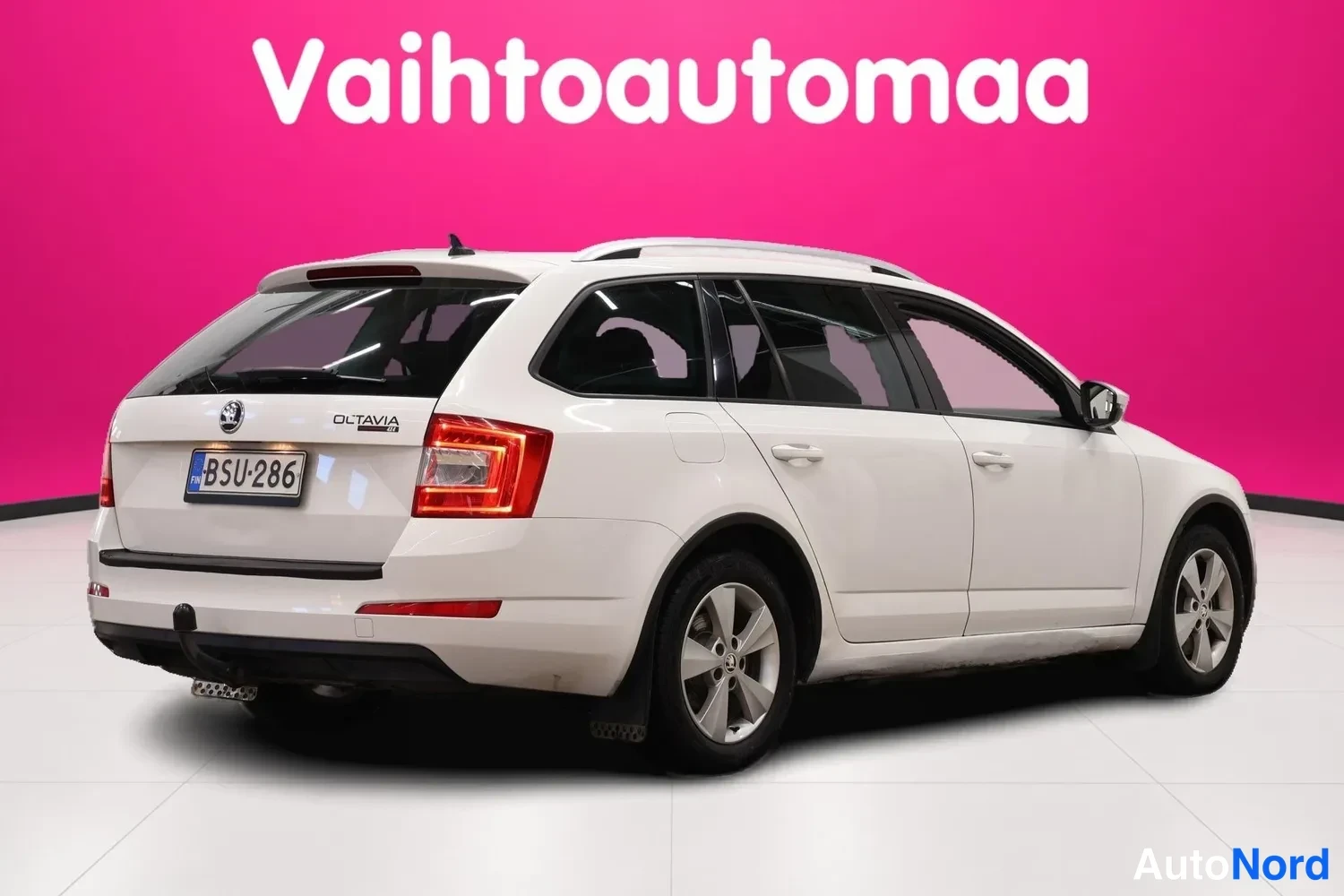 Takaviisto: Valkoinen Skoda Octavia Combi -farmari takaviistosta kuvattuna, takavalot ja rekisterikilpi näkyvät, pyörät ja kylki näkyvät.