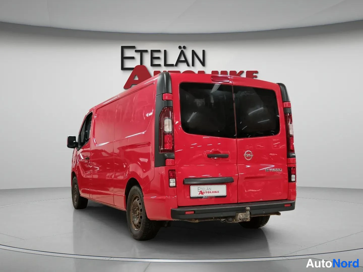 Takaviisto: Punainen Opel Vivaro -pakettiauto takaosasta ja sivulta kuvattuna, tummat takaluukut ja vetokoulu takapuskurissa.