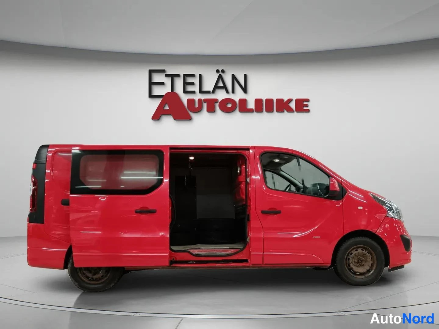 Sivulta: Punainen pakettiauto sivulta kuvattuna, takaovet ja liukusivuovi auki.