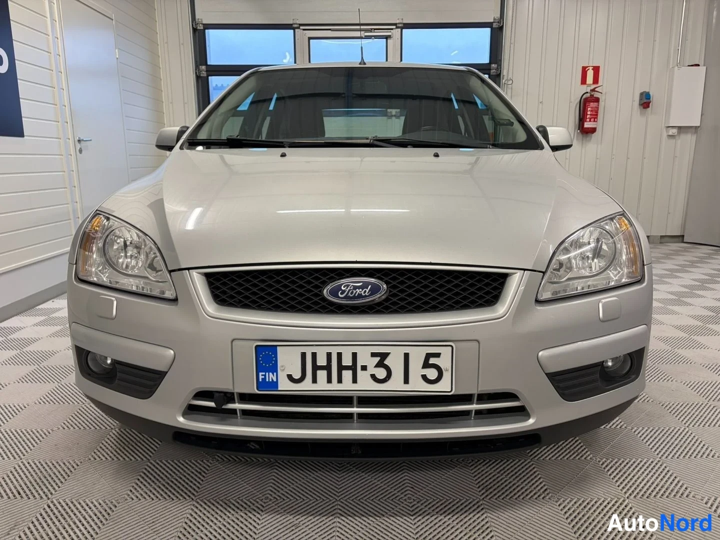 Edestä: Hopeanvärinen Ford Focus suoraan edestä, Ford-merkki koossa ja rekisterikilpi.