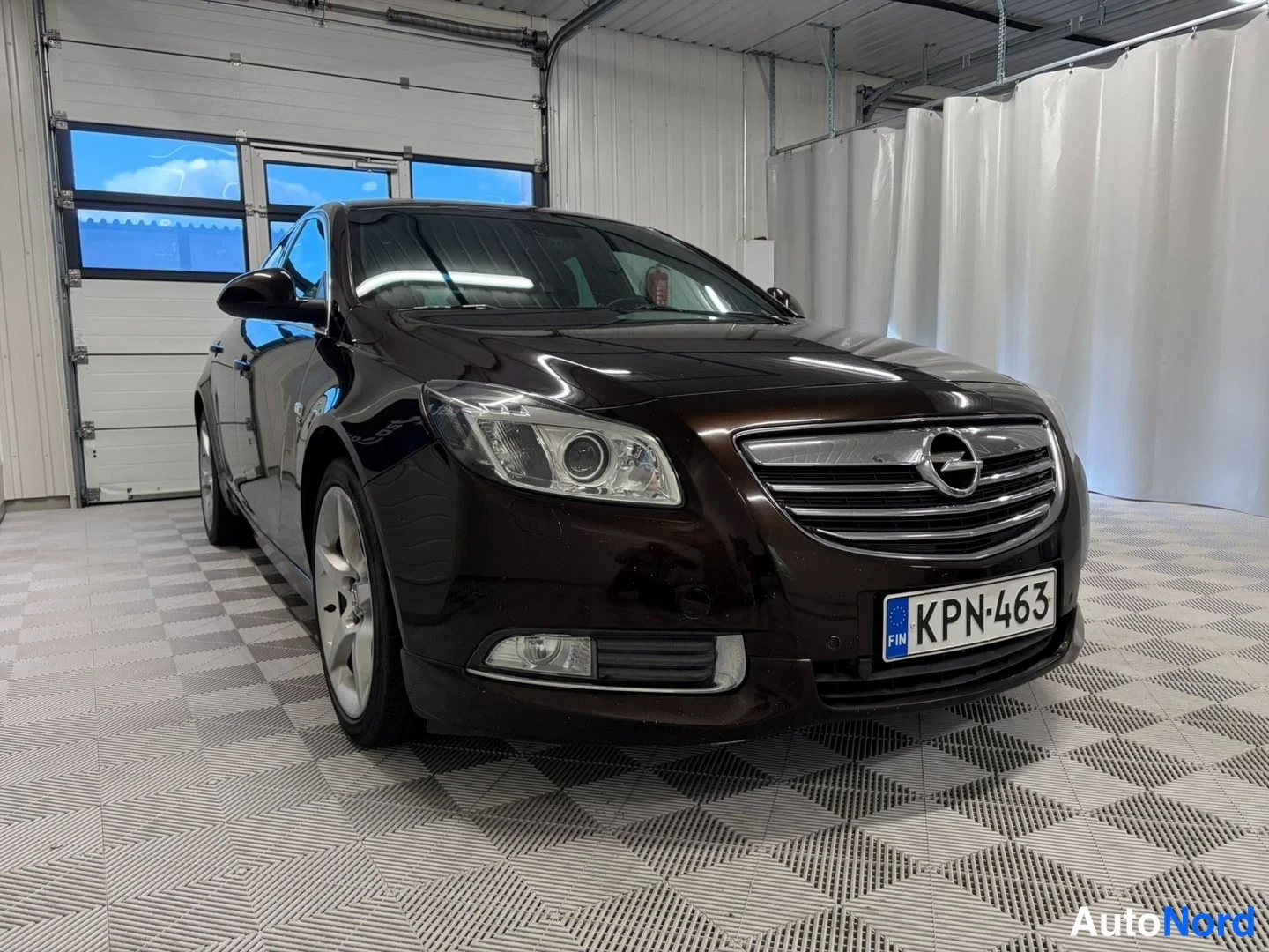Etuviisto, nokka oikealle: Tummanruskea Opel Insignia etuviistosta oikealta, rekisterikilpi