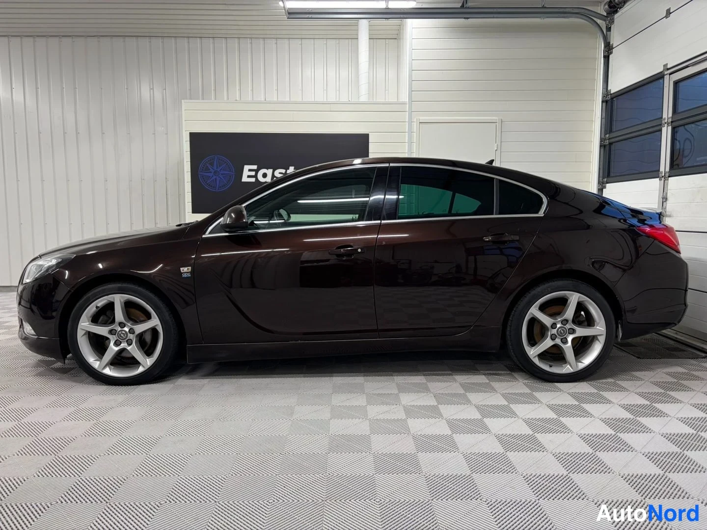Sivulta: Tummanruskea Opel Insignia sivulta, viisiovinen korimalli tummennetuilla ikkunoilla ja kevytmetallivanteilla