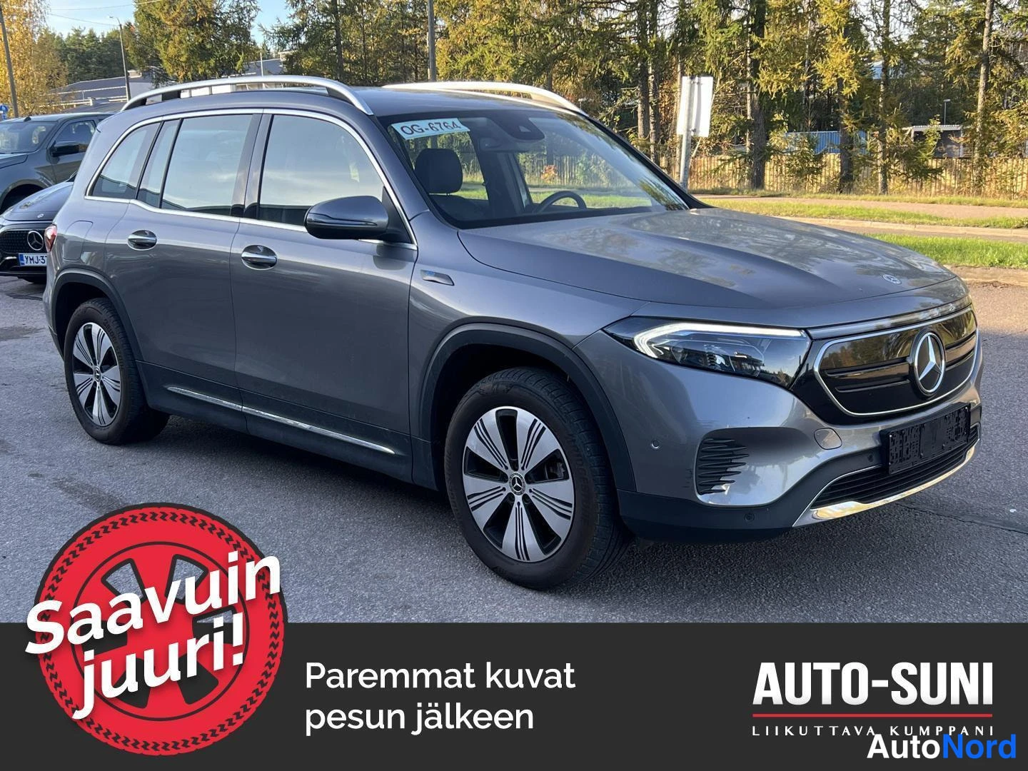 Etuviisto, nokka oikealle: Mercedes-Benz EQB:n etukulmakuva oikealta, harmaa pokkara autotallin pihalla.