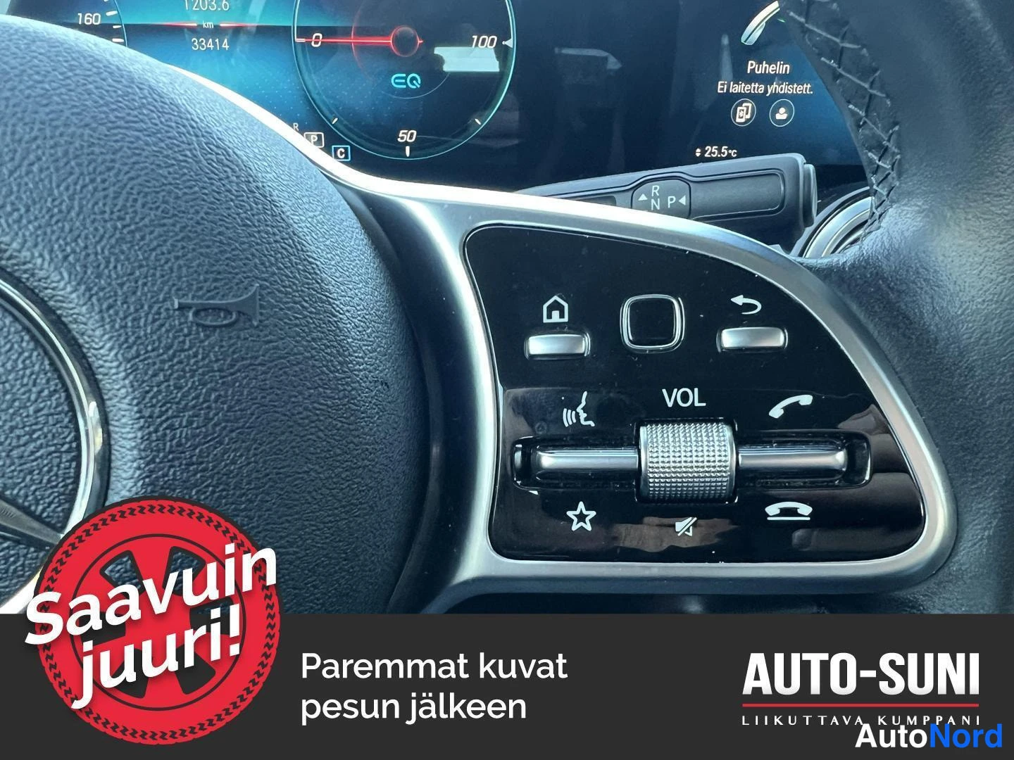 Yksityiskohta: Sisätilakuvan detalji Mercedes-Benzin ohjauspyörän oikean puolen audio- ja puhelinohjaimista VOL-merkeillä ja taustalla digitaalinen mittaristo.