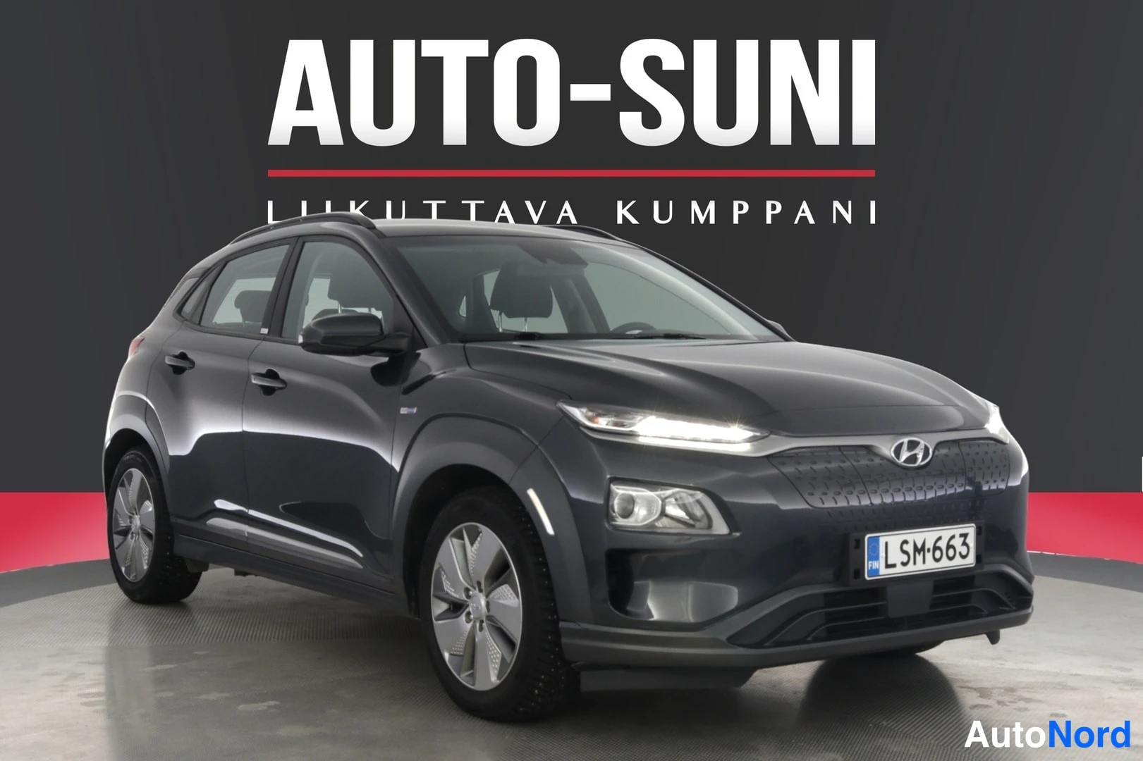 Etuviisto, nokka oikealle: Hyundai Kona electric tummanharmaa etu-neljänneskuvassa rekisterikilpi