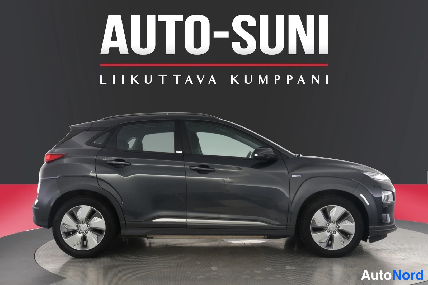 Etuviisto, nokka oikealle: Hyundai Kona tummanharmaa, sivukulma korostaa profiilia ja kevytmetallivanteita studioissa.
